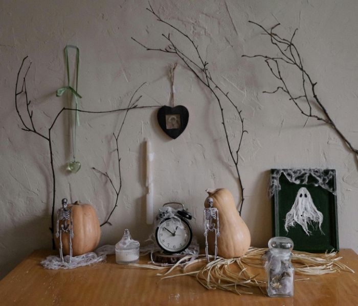 vintage halloween decor, cream pumpkins, twigs, skeletons, old alarm clock etc