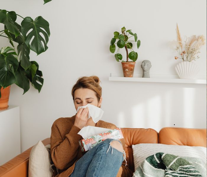 lady blowing nose on sofa