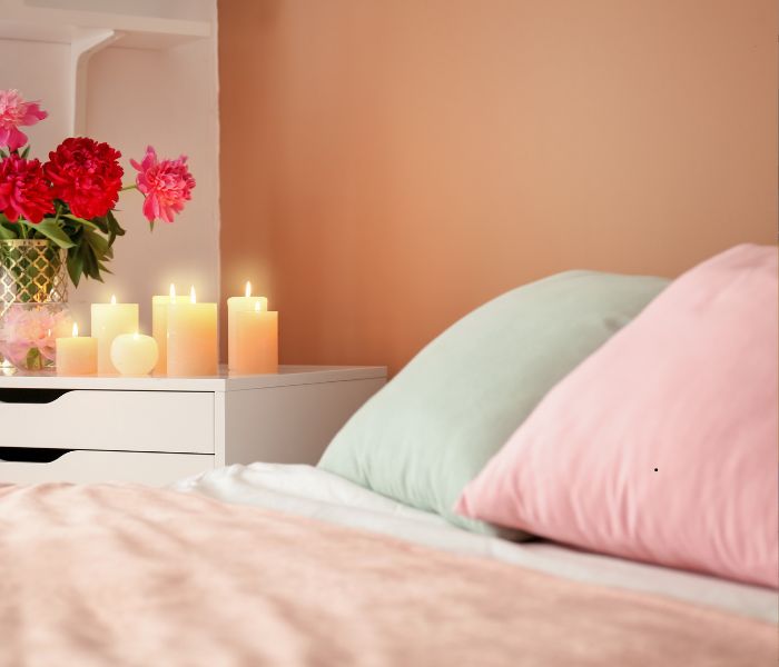 pink bedding with roses and candles on the bedside table