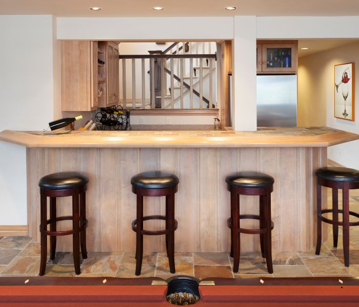 stools next to a bar with stairs in the background
