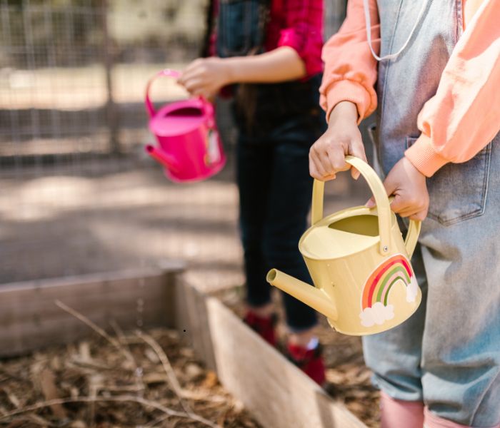 kids in garden holding watering cans